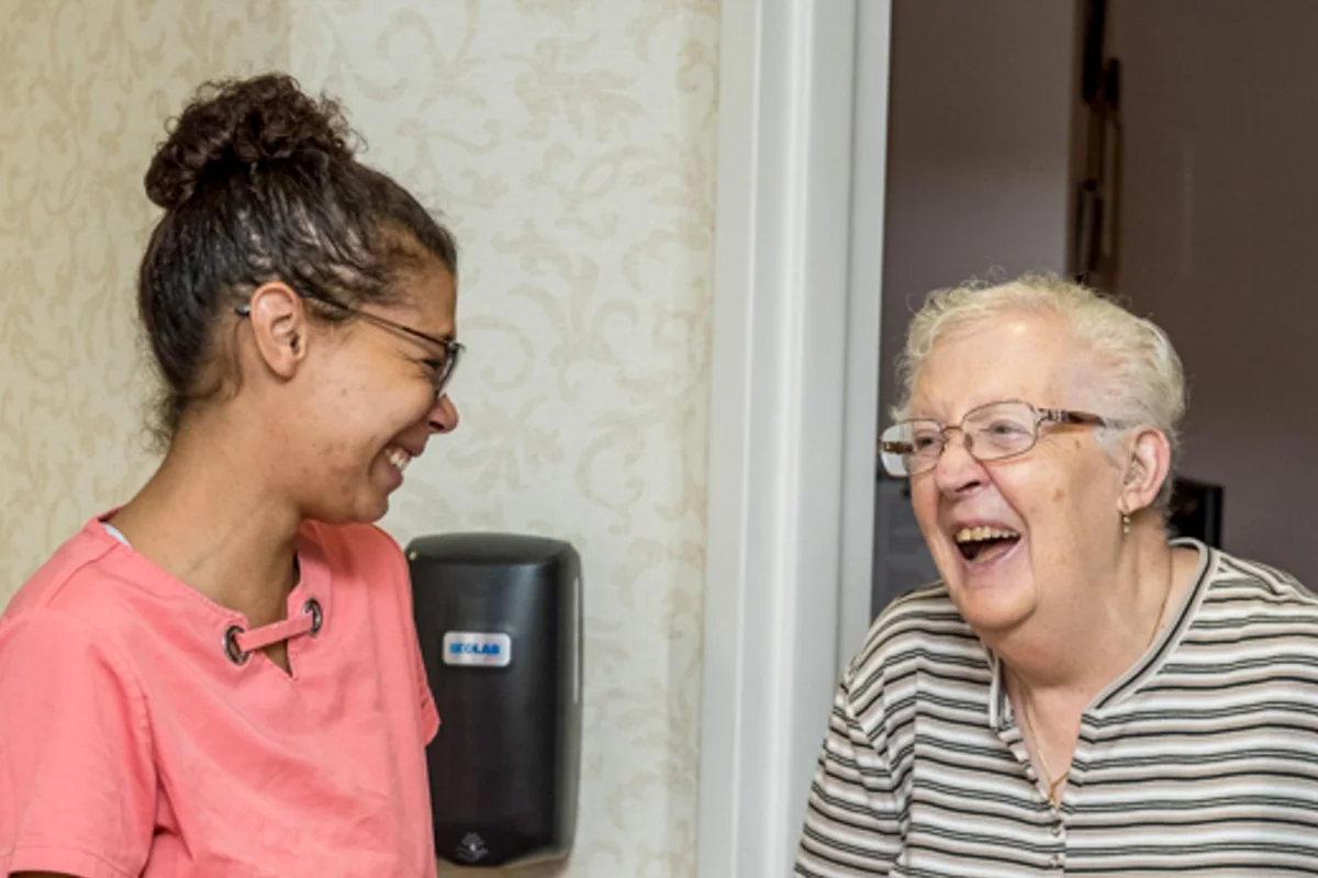 nurses aid and resident laughing together